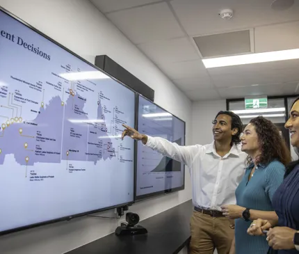 NAIF Staff At Cairns Headquarters Board Room Looking At Prohjects Map