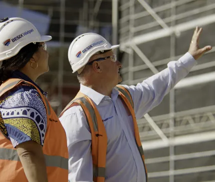 Besix Watpac Workers Wearing PPE Inspecting JCU Engineering And Innovation Place Construction Site With Scaffolding In Background